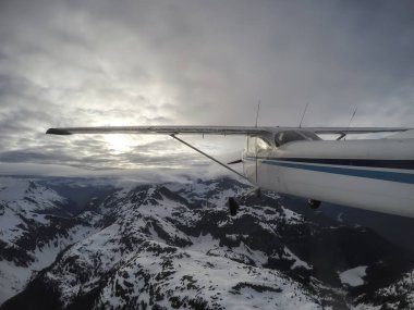 Bulutlu bir gece boyunca güzel Kanada dağ peyzaj üzerinde uçan uçak. Vancouver, British Columbia, Kanada kuzeyindeki alınan.