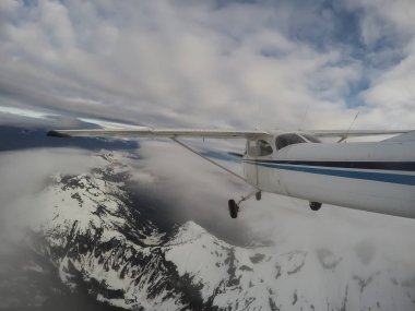 Bulutlu bir gece boyunca güzel Kanada dağ peyzaj üzerinde uçan uçak. Vancouver, British Columbia, Kanada kuzeyindeki alınan.