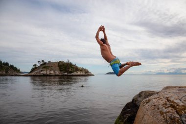 Bir kayadan denize atlama cliff maceracı biri. Whytecliff Park, Horseshoe Bay, Batı Vancouver, Bc, Kanada içinde alınan.