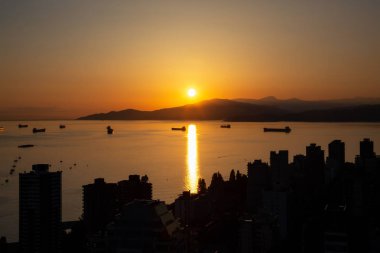 Güzel ve renkli bir gün batımı karanlık şehrin arka planda dağlar üzerinde sanatsal hava görünümünü. Şehir merkezinde alınan Vancouver, Bc, Kanada.