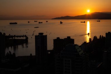 Güzel ve renkli bir gün batımı karanlık şehrin arka planda dağlar üzerinde sanatsal hava görünümünü. Şehir merkezinde alınan Vancouver, Bc, Kanada.