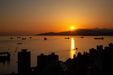 Güzel ve renkli bir gün batımı karanlık şehrin arka planda dağlar üzerinde sanatsal hava görünümünü. Şehir merkezinde alınan Vancouver, Bc, Kanada.