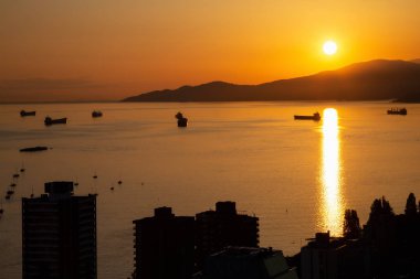 Güzel ve renkli bir gün batımı karanlık şehrin arka planda dağlar üzerinde sanatsal hava görünümünü. Şehir merkezinde alınan Vancouver, Bc, Kanada.