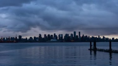 Şehir şehir zaman atlamalı dramatik bir bulutlu gün batımı sırasında. Lonsdale, North Vancouver, British Columbia, Kanada alınan.