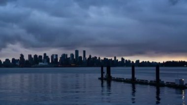 Şehir şehir zaman atlamalı dramatik bir bulutlu gün batımı sırasında. Lonsdale, North Vancouver, British Columbia, Kanada alınan.