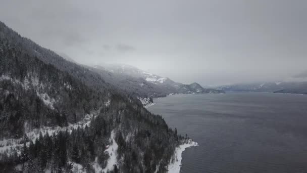 雪の空撮では クートネー湖で冬の間を通る道路を覆われています ブリティッシュ コロンビア州 カナダのインテリアは — ストック動画