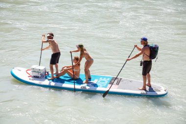 Squamish, British Columbia, Kanada - 14 Temmuz 2018: Maceracı grup arkadaşıyla vardır bir büyük hava ile şişirilen kürek kurulu bir nehir.