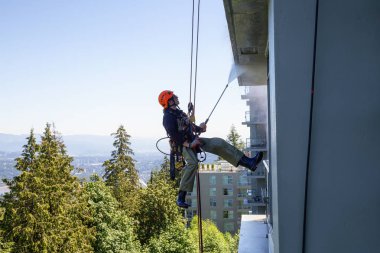 Burnaby dağ, Vancouver, British Columbia, Kanada - 011 Temmuz 2018: Yüksek doğmak ip access penceresi temiz bina bir sıcak güneşli yaz gün boyunca yıkama güçtür.