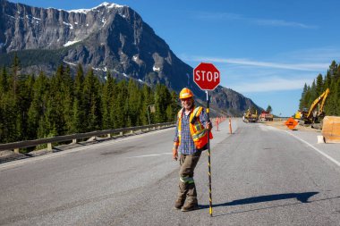 Banff National Park, Alberta, Kanada - 20 Haziran 2018: Trafik denetim Flagger güneşli yaz gün boyunca karayolu üzerinde çalışıyor.