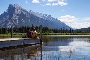 Banff, Alberta, Kanada - 19 Haziran 2018: Çift arkadaş güzel görünüm ahşap bir iskele üzerinde tadını çıkarıyor.