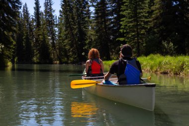 Kaç maceracı arkadaşlar Kanada doğa ile çevrili bir nehirde Kano. Alınan Vermilion göllerde, Banff, İngiltere.
