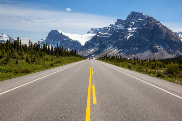 Scenic road in the Canadian Rockies during a vibrant sunny summer day. Taken in Icefields Parkway, Banff National Park, Alberta, Canada.