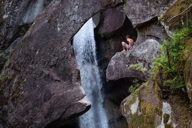 Squamish, British Columbia, Kanada - 29 Temmuz 2018: Maceracı adam Monmouth kanyonunda bir uçurumun üstünde oturuyor.