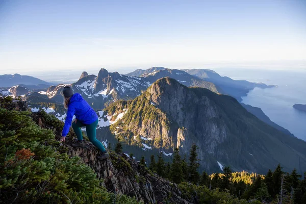 Adventurous woman hiking in the mountains during a sunny summer day. Taken on Mount Brunswick, Lions Bay, North of Vancouver, BC, Canada.