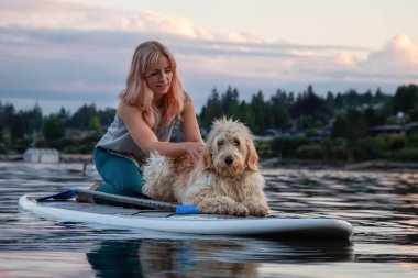 Canlı bir yaz günbatımında köpekli bir kız. Deep Cove 'da çekildi, Kuzey Vancouver, BC, Kanada.