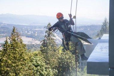 Yüksek doğmak ip access penceresi temiz bina bir sıcak güneşli yaz gün boyunca yıkama güçtür. Burnaby dağda, Vancouver, Bc, Kanada alınan.