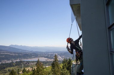 Burnaby dağ, Vancouver, British Columbia, Kanada - 011 Temmuz 2018: Yüksek doğmak ip access penceresi temiz bina bir sıcak güneşli yaz gün boyunca yıkama güçtür.