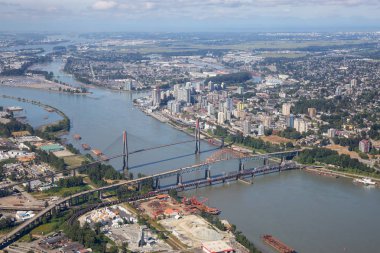Aerial city view of Pattullo and Skytrain Bridge across the Fraser River. Taken in Greater Vancouver, British Columbia, Canada. clipart
