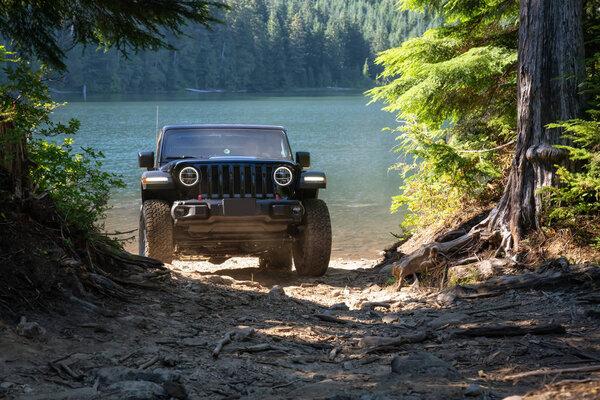 Миссия, Британская Колумбия, Канада - 6 августа 2018 года: Jeep Rubicon едет по труднопроходимой местности к озеру
.
