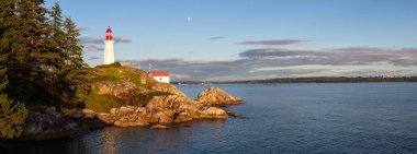 Canlı bir bulutlu gün batımı sırasında kayalık bir kıyısında deniz feneri. Horseshoe Bay, Batı Vancouver, British Columbia, Kanada alınan.
