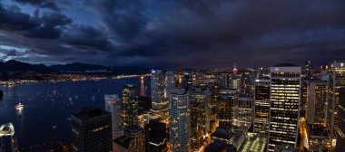 Vancouver, British Columbia, Kanada - 1 Temmuz 2018: Modern şehir merkezinde şehir manzarası bulutlu bir gün batımı hava panoramik manzaralı.