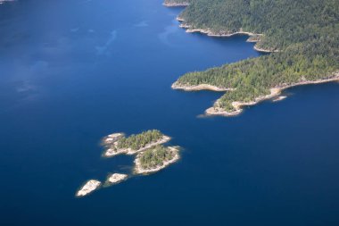 Aerial view of the rocky islands in Sechelt Inlet during a sunny summer day. Located in Sunshine Coast, Northwest of Vancouver, BC, Canada. clipart