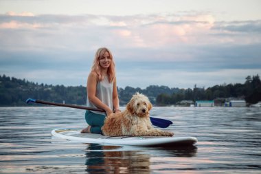 Canlı bir yaz günbatımında köpekli bir kız. Deep Cove 'da çekildi, Kuzey Vancouver, BC, Kanada.