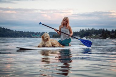 Canlı bir yaz günbatımında köpekli bir kız. Deep Cove 'da çekildi, Kuzey Vancouver, BC, Kanada.
