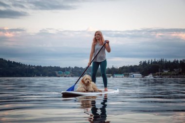 Canlı bir yaz günbatımında köpekli bir kız. Deep Cove 'da çekildi, Kuzey Vancouver, BC, Kanada.
