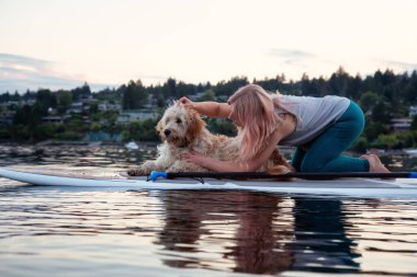 Canlı bir yaz günbatımında köpekli bir kız. Deep Cove 'da çekildi, Kuzey Vancouver, BC, Kanada.