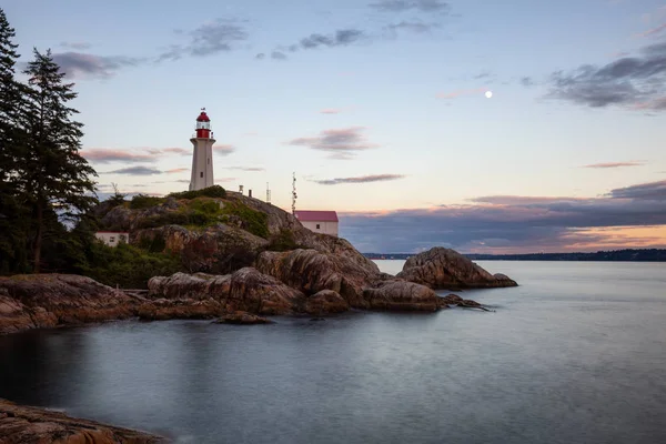 Canlı bir bulutlu gün batımı sırasında kayalık bir kıyısında deniz feneri. Horseshoe Bay, Batı Vancouver, British Columbia, Kanada alınan.