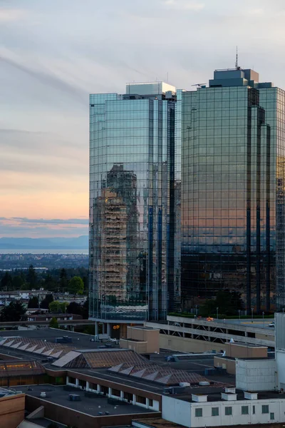 Aerial view of commercial and residential buildings during a vibrant summer sunset. Located near Metrotown Mall, Burnaby, Vancouver, BC, Canada.
