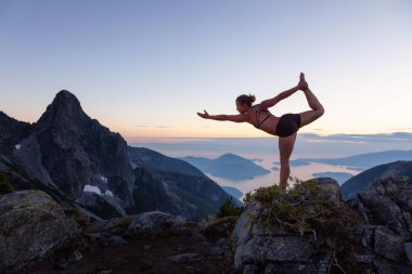 Pratik yoga bir dağın tepesinde bir canlı yaz gün batımı sırasında kız. Vancouver, Bc, Kanada yakınındaki Howe ses alınan.