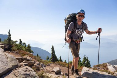Adam bir canlı yaz gün batımı sırasında hiking. Vancouver, Bc, Kanada yakınındaki Howe ses alınan.