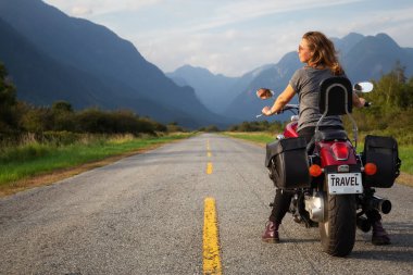 Kadın Kanada dağlarla çevrili doğal bir yol üzerinde bir motosiklet Binme. Pitt Meadows, büyük Vancouver, Bc, Kanada alınan.