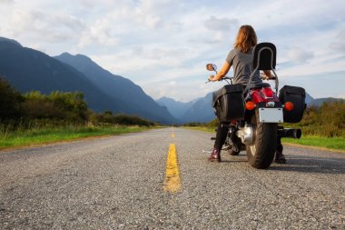 Kadın Kanada dağlarla çevrili doğal bir yol üzerinde bir motosiklet Binme. Pitt Meadows, büyük Vancouver, Bc, Kanada alınan.