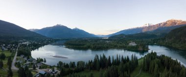 Aerial panoramic view of Revelstoke during a vibrant summer sunrise. Located in the Interior BC, Canada. clipart