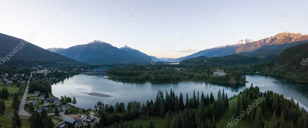 Aerial panoramic view of Revelstoke during a vibrant summer sunrise. Located in the Interior BC, Canada.
