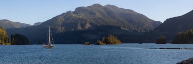 Bir okyanus girişi bir canlı yaz gün batımı sırasında bir Yelkenli tekne ile güzel panoramik manzara görünümü. Bağlantı noktası alis, Kuzey Vancouver Adası, Bc, Kanada alınan.