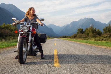 Kadın Kanada dağlarla çevrili doğal bir yol üzerinde bir motosiklet Binme. Pitt Meadows, büyük Vancouver, Bc, Kanada alınan.