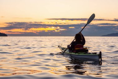 Kız deniz kanosu bir canlı güneşli yaz gün batımı sırasında. Vancouver, Bc, Kanada içinde alınan.