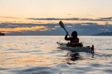 Kız deniz kanosu bir canlı güneşli yaz gün batımı sırasında. Vancouver, Bc, Kanada içinde alınan.