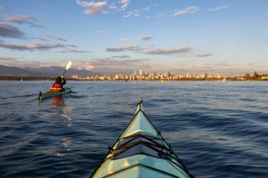 Bir canlı güneşli yaz gün batımı sırasında deniz kanosu şehir şehir önünde. Vancouver, Bc, Kanada içinde alınan.