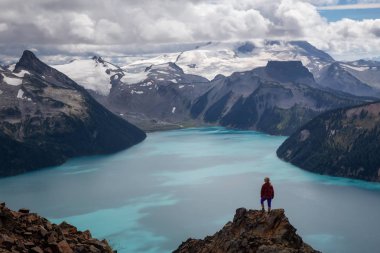 Bir güzel buzul Gölü bakan dağın tepesinde duran kadın. Panorama Ridge, Garibaldi, Whistler, Bc, Kanada yakın üzerinde gerçekleştirilen.