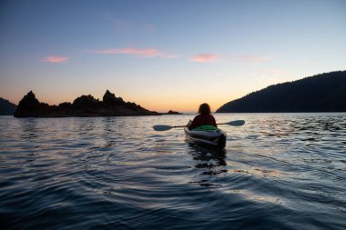 Pasifik Okyanusu'nda bir bulutlu yaz gün batımı sırasında kayak kız. San Josef Bay, Cape Scott, Kuzey Vancouver Adası, Bc, Kanada içinde alınan.