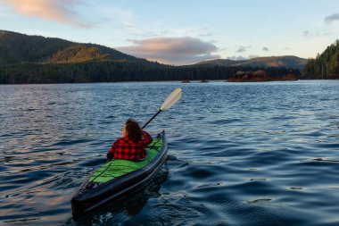 Pasifik Okyanusu'nda bir bulutlu yaz gün batımı sırasında kayak kız. San Josef Bay, Cape Scott, Kuzey Vancouver Adası, Bc, Kanada içinde alınan.
