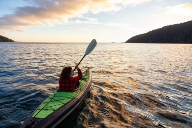 Pasifik Okyanusu'nda bir bulutlu yaz gün batımı sırasında kayak kız. San Josef Bay, Cape Scott, Kuzey Vancouver Adası, Bc, Kanada içinde alınan.