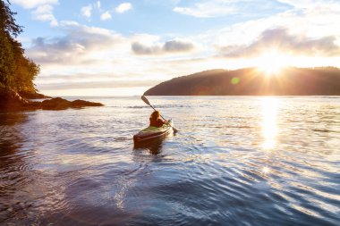Pasifik Okyanusu'nda bir bulutlu yaz gün batımı sırasında kayak kız. San Josef Bay, Cape Scott, Kuzey Vancouver Adası, Bc, Kanada içinde alınan.