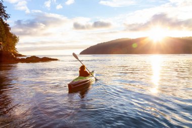 Pasifik Okyanusu'nda bir bulutlu yaz gün batımı sırasında kayak kız. San Josef Bay, Cape Scott, Kuzey Vancouver Adası, Bc, Kanada içinde alınan.