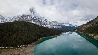 Hava panoramik manzaralı bir bulutlu gün boyunca Kanada Rocky Dağları ile çevrili bir buzul Gölü. Banff, Alberta, Kanada içinde alınan.